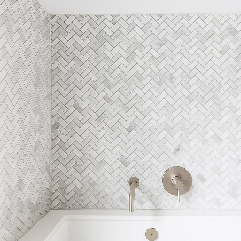 Mur salle de bain recouvert de carrelage en marbre chevron blanc et gris