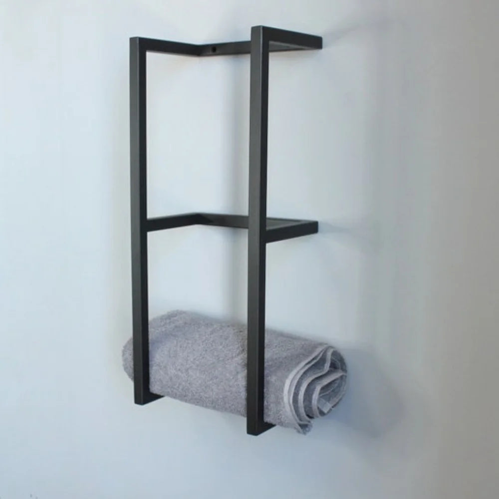 Vue de profil d'un porte-serviette mural en métal noir mat, montrant sa structure géométrique avec une serviette grise.